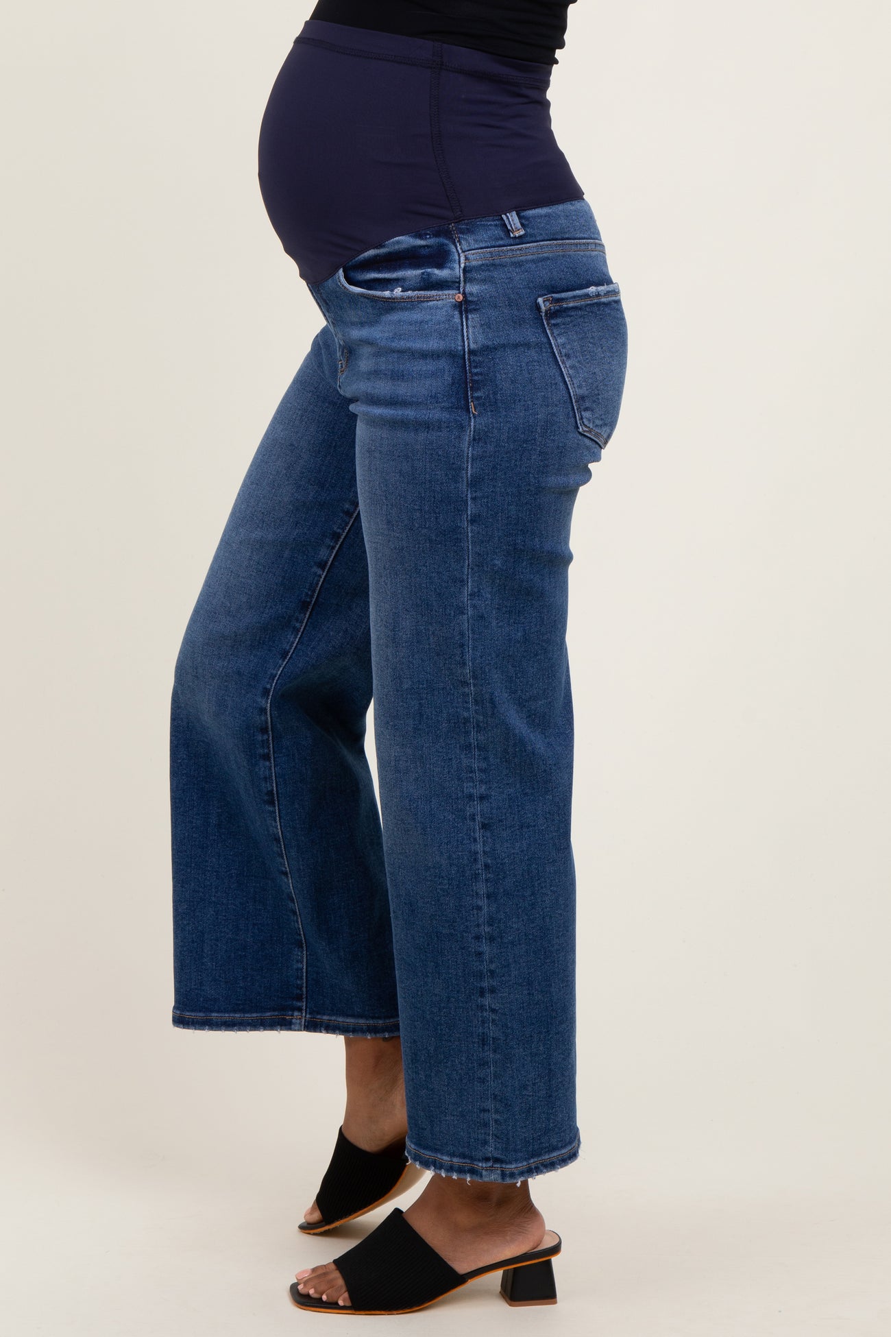 maternity wear dark blue wide leg jeans with a stretchy panel and visible baby bump on the model