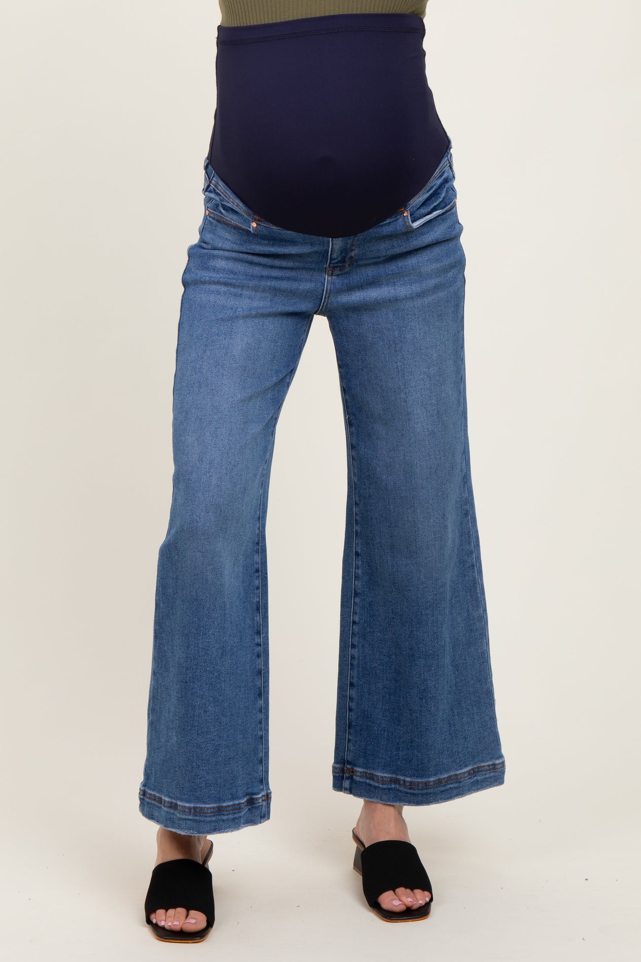 woman wearing a pair of blue maternity flared jeans with a supportive belly panel