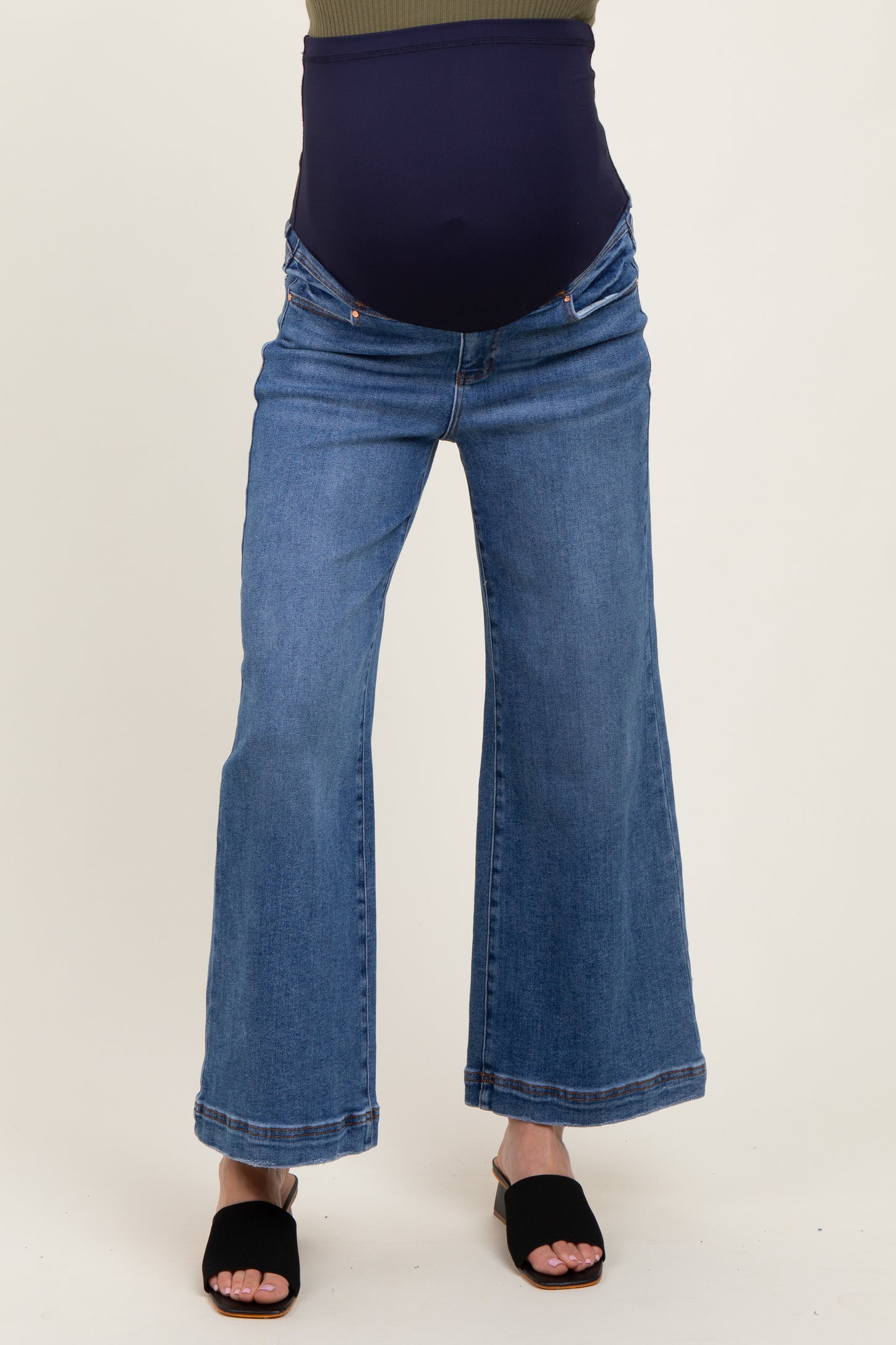 woman wearing a pair of blue maternity flared jeans with a supportive belly panel