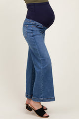 woman wearing a dark blue maternity wide-leg jeans with a panel for a baby bump.