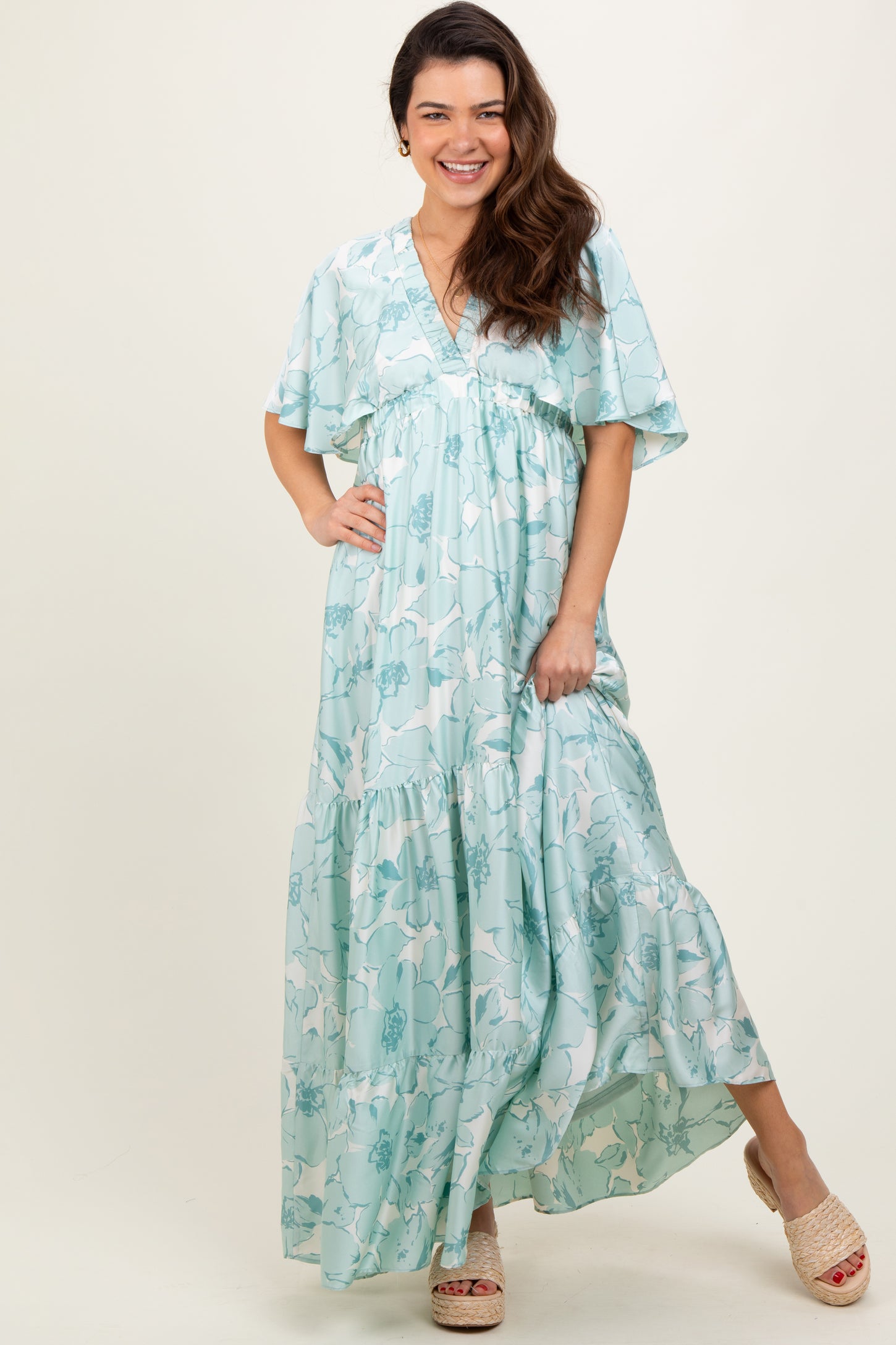 woman wearing a light blue floral maxi dress with short sleeves and a tiered skirt