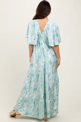 woman wearing a light blue floral maxi dress with flutter sleeves and a back tie detail