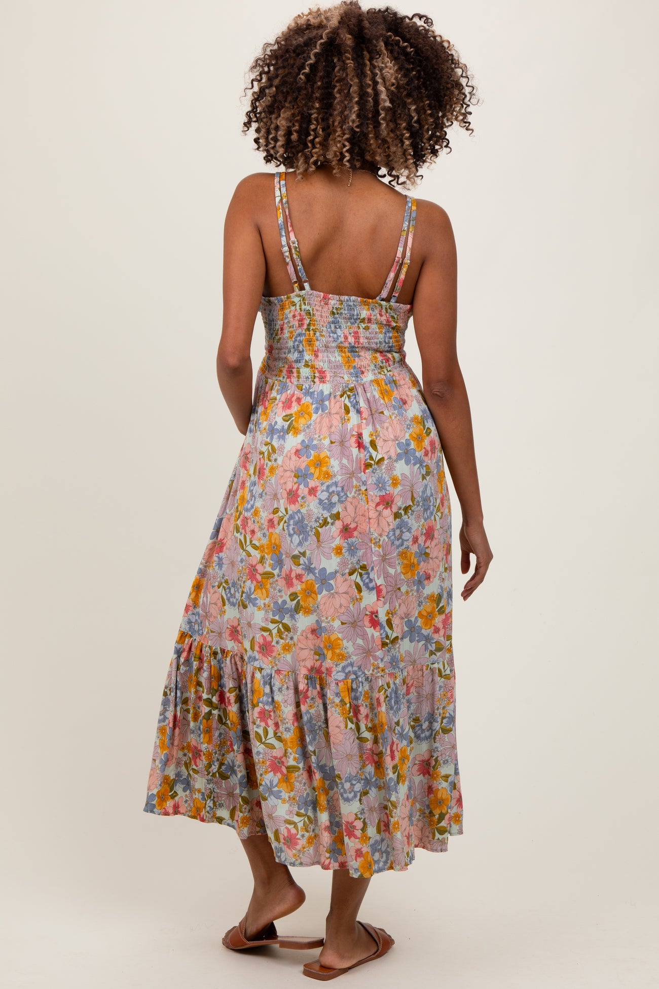 woman wearing a floral maternity maxi dress with a smocked back and tiered hem, showing a relaxed silhouette