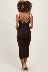 woman wearing a dark brown maternity midi dress with white strap detailing, showing off a baby bump from the back