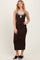 woman wearing a brown midi dress with contrasting white trim and a keyhole detail at the neckline