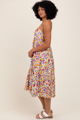 woman wearing a colorful floral print midi dress with spaghetti straps and a flared skirt