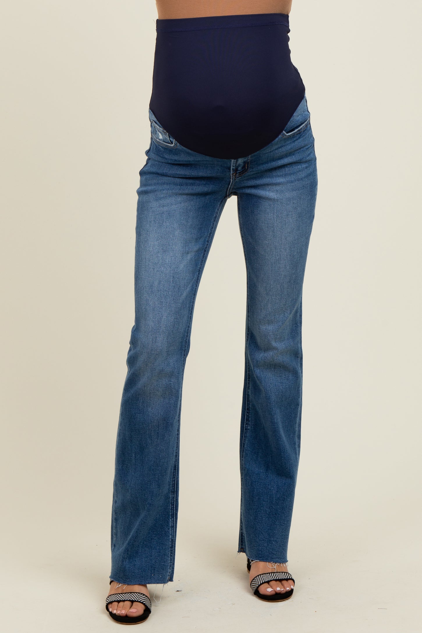 woman wearing a pair of blue maternity flared jeans with a navy belly panel