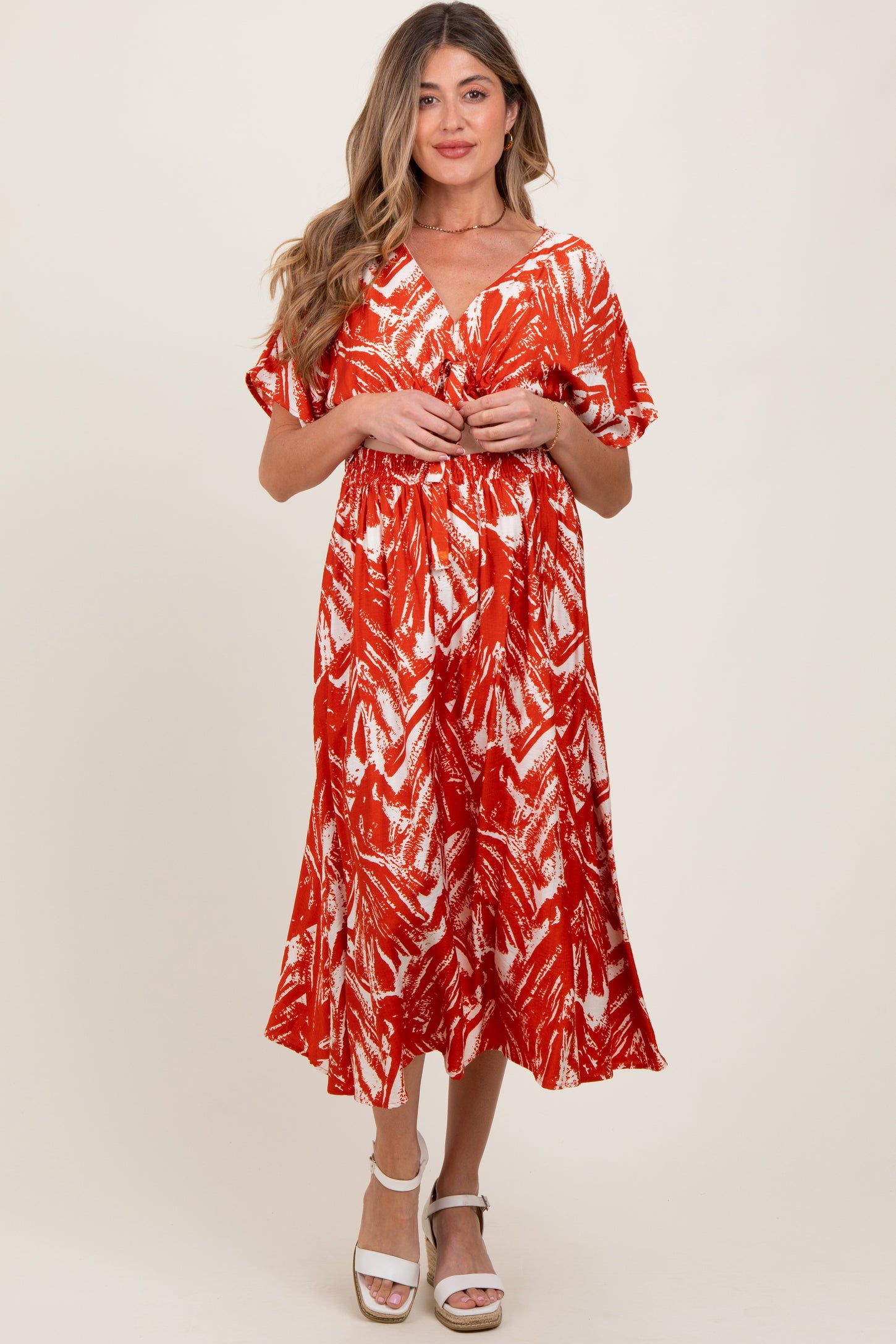 woman wearing a red and white patterned maternity dress with short sleeves and a flowy skirt