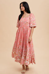 woman wearing a pink floral maxi dress with puff sleeves and a square neckline