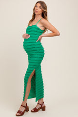woman wearing a green ribbed maternity maxi dress with side slit and holding her baby bump