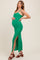 woman wearing a green ribbed maternity maxi dress with side slit and holding her baby bump