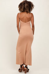 woman wearing a light brown maternity maxi dress with thin straps, viewed from the back