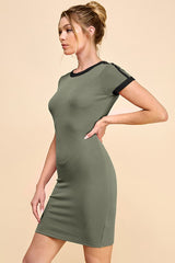 woman wearing an olive green short sleeve bodycon dress with black trim on the neckline and sleeves