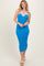 woman wearing a bright blue ribbed midi dress with a white contrast neckline and sandals