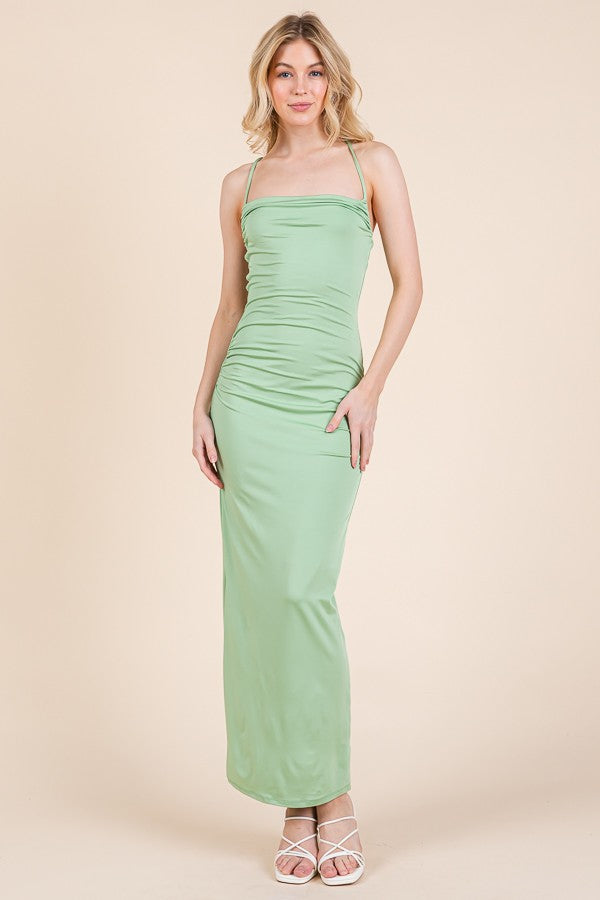 woman wearing a mint green spaghetti strap maxi dress with ruching details