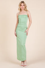 woman wearing a mint green spaghetti strap maxi dress with ruching details
