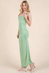 woman wearing a mint green strapless maxi dress with side ruching and strappy white heels