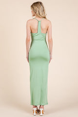 woman wearing a green backless maxi dress with a halter neck and fitted silhouette