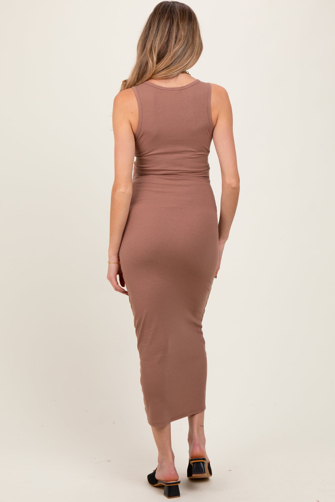 woman wearing a brown ribbed maternity dress with a fitted silhouette and midi length