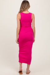 woman wearing a bright pink tank midi maternity dress, showing a snug fit and a sleeveless design