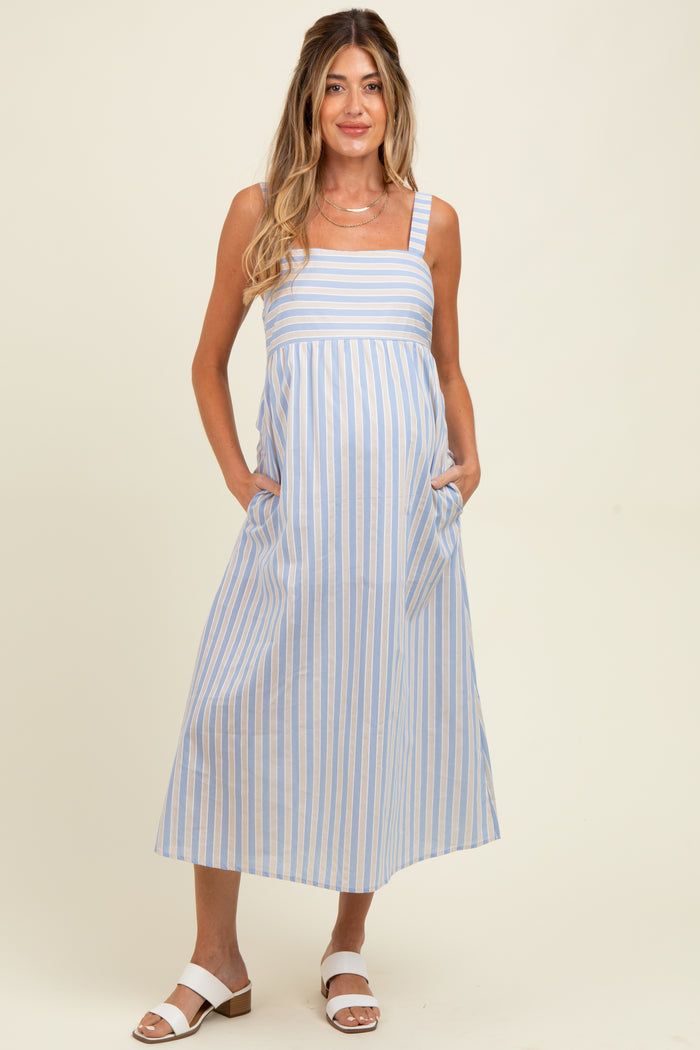 woman wearing a blue and white striped maternity dress with pockets and a baby bump visible