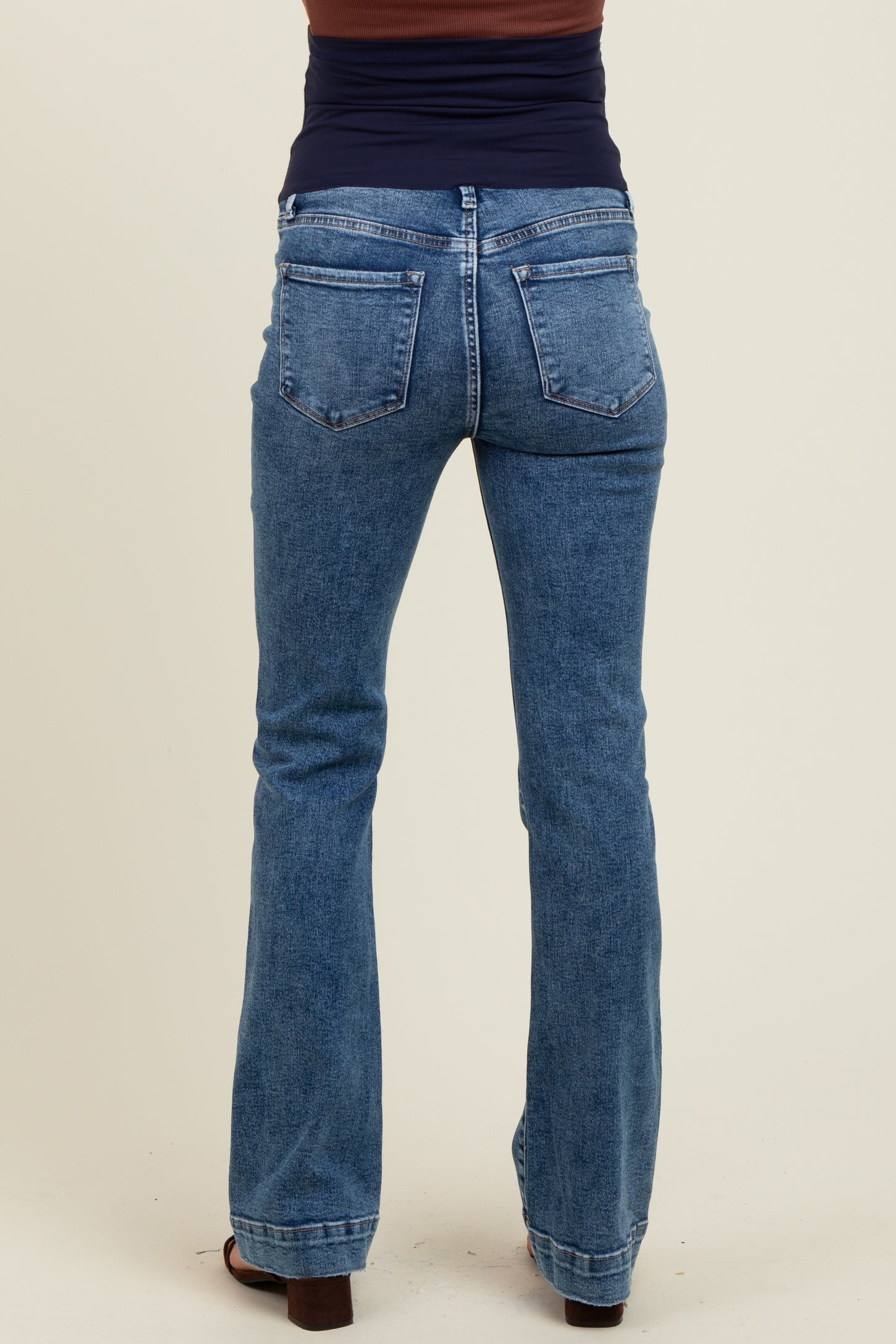 woman wearing blue maternity bootcut jeans seen from the back