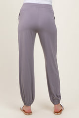 woman wearing light gray maternity jogger pants with elastic cuffs and side pockets, showing back view