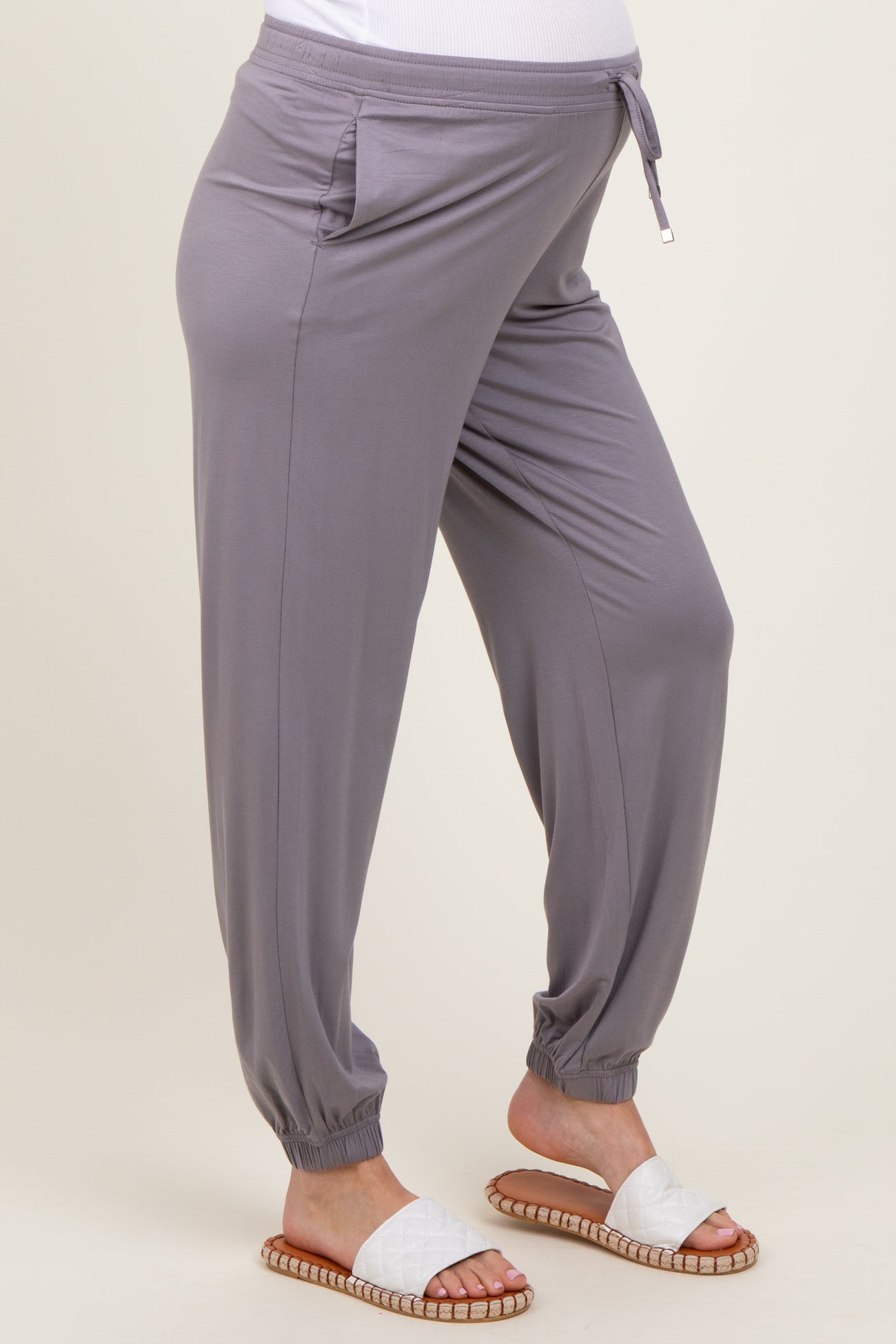 woman wearing grey maternity jogger pants with side pockets and tapered cuffs