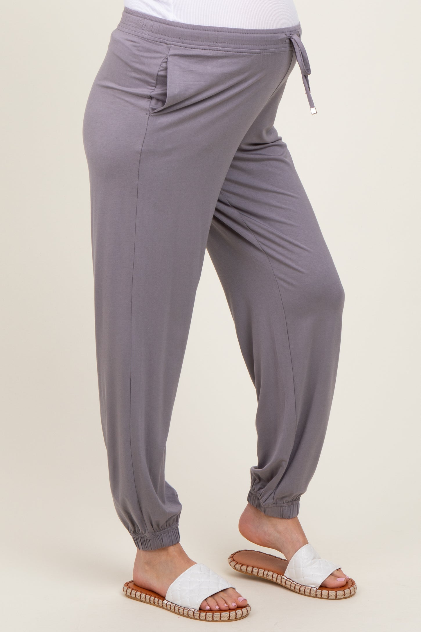 woman wearing grey maternity jogger pants with side pockets and tapered cuffs