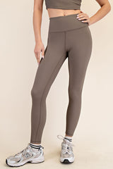 woman wearing brown high-waisted ribbed leggings paired with silver athletic shoes
