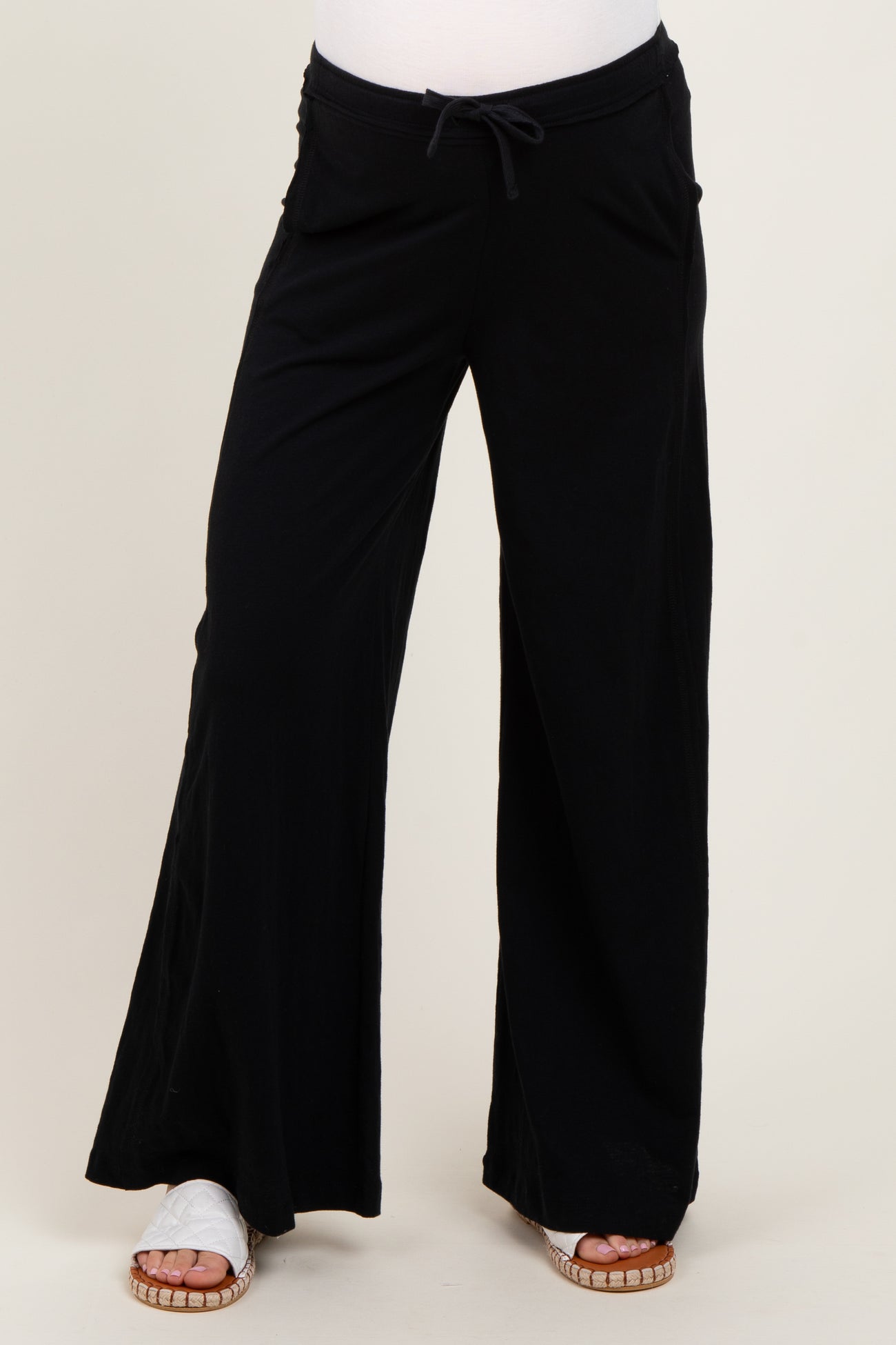 woman wearing black wide-leg maternity pants with side pockets and a drawstring waistband