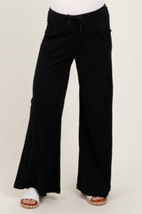woman wearing black wide-leg maternity pants with side pockets and a drawstring waistband