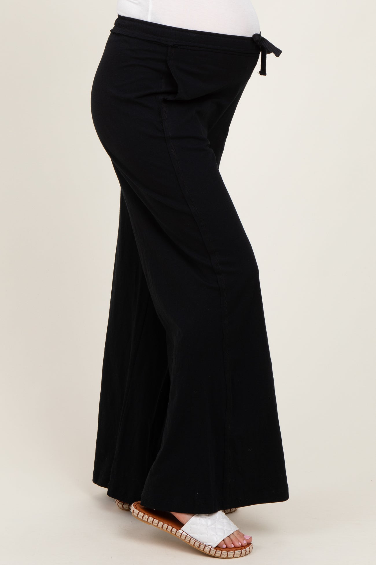maternity black wide-leg pants with a tie waist and a visible baby bump