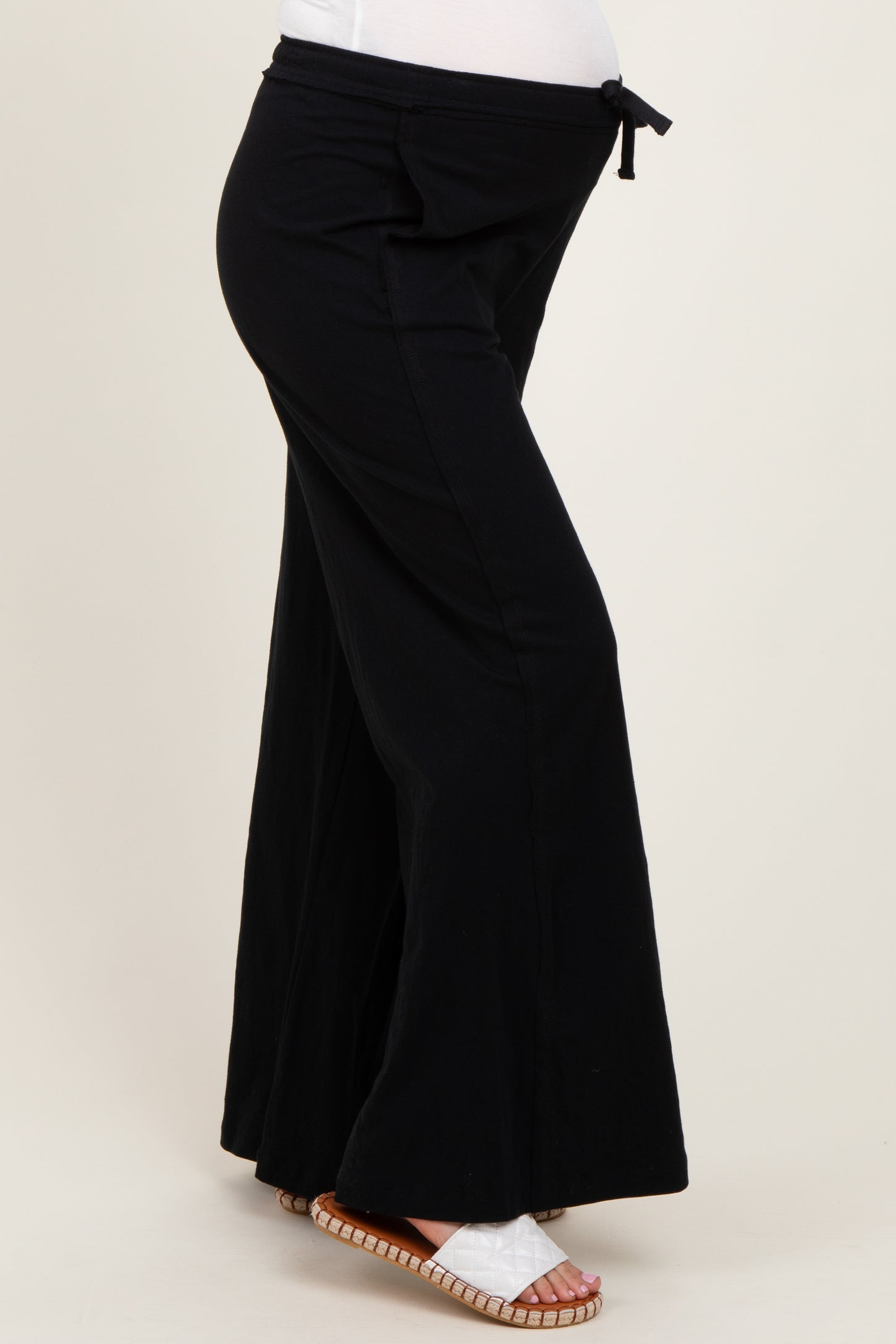 maternity black wide-leg pants with a tie waist and a visible baby bump