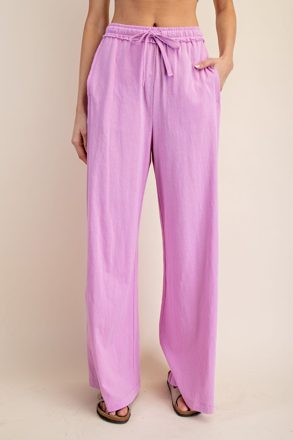 woman wearing light pink wide-leg pants with an adjustable drawstring waist and side pockets