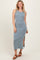 woman wearing a light blue ribbed sleeveless maxi dress with a side slit and brown block-heeled sandals