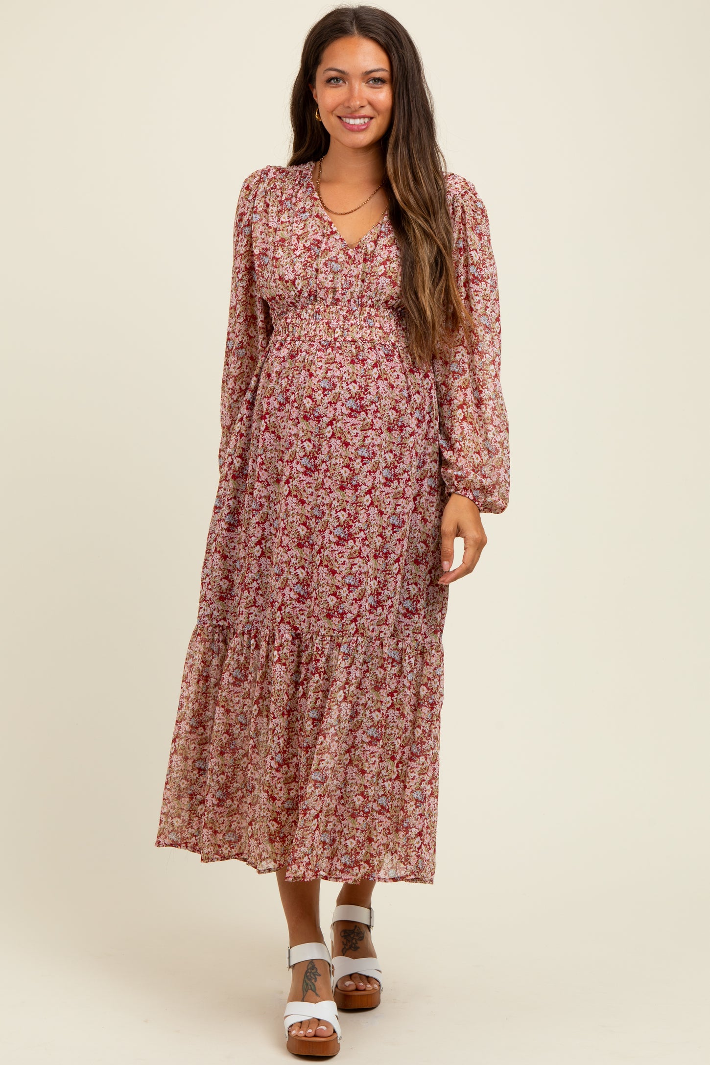 woman wearing a floral long sleeve maternity dress with a baby bump and tiered skirt