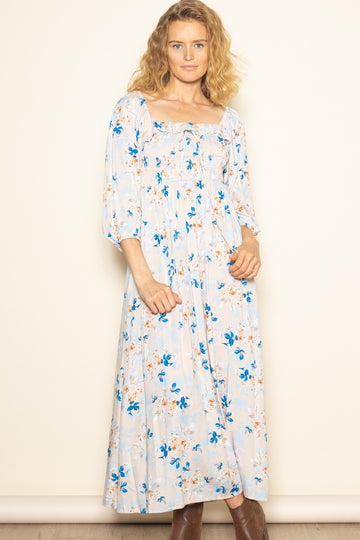 woman wearing a light blue floral maxi dress with puff sleeves and a smocked bodice