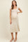 woman wearing a cream short sleeve ribbed maternity dress with a fitted silhouette and visible baby bump