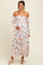 woman wearing a floral off-the-shoulder maternity dress with a flowing skirt and holding her baby bump
