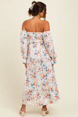 woman wearing a floral off-shoulder maternity maxi dress with a smocked bodice and tiered skirt