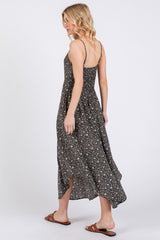 woman wearing a black floral maxi dress with spaghetti straps, seen from the back, styled with brown sandals