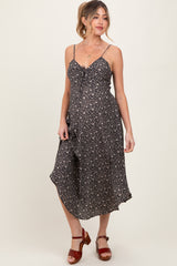 woman wearing a black floral midi maternity dress with spaghetti straps and a tied front detail, baby bump visible