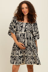 woman wearing a black and white floral maternity dress with short sleeves and a baby bump visible