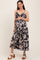 woman wearing a navy and beige floral maternity dress with adjustable straps and a visible baby bump