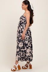 woman wearing a navy floral maternity maxi dress with adjustable straps and a visible baby bump