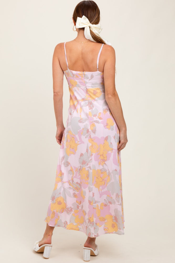 woman wearing a back view of a floral maxi dress with pink and yellow patterns, featuring adjustable straps