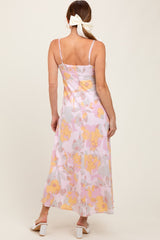 woman wearing a back view of a floral maxi dress with pink and yellow patterns, featuring adjustable straps