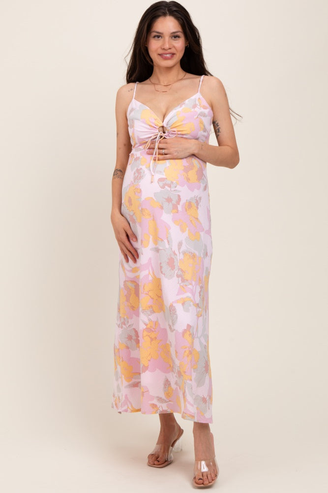 woman wearing a pink floral maternity maxi dress with a tie-front detail and a visible baby bump