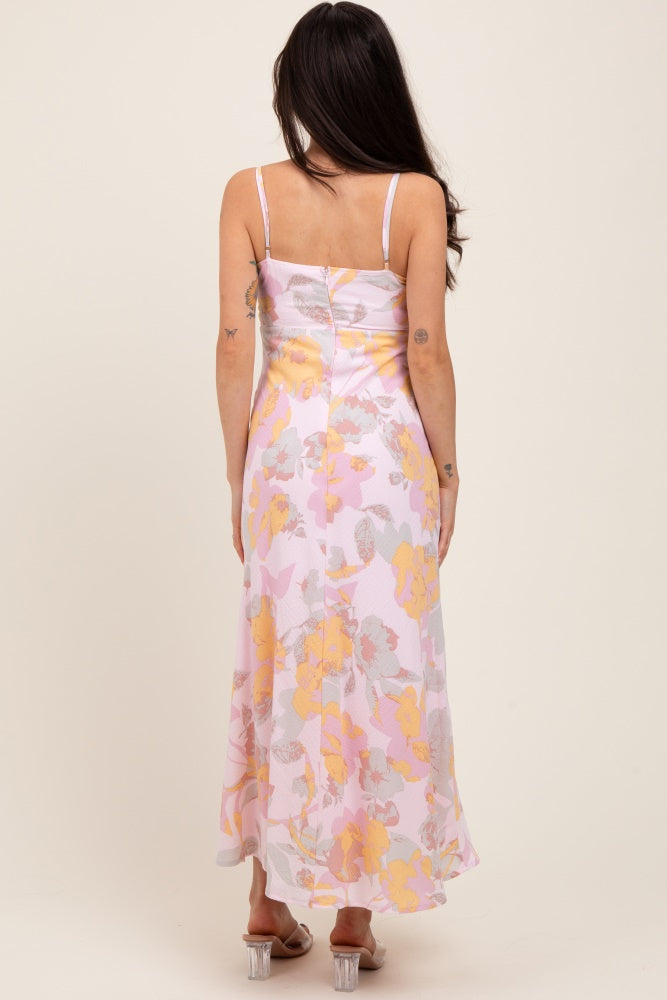 woman wearing a maternity floral maxi dress in pastel colors, showing the back view with a flowing silhouette